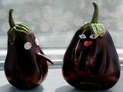 a pair of toy eggplant on the window