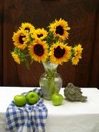 still life with a bouquet of sunflowers and apples