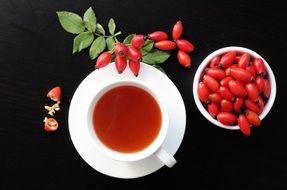 cup of tea next to wild rose fruits