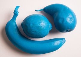 Blue banana,lemon and pear on the white table