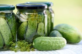 fresh and pickled cucumbers in a jar