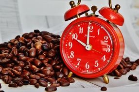photo of a red alarm clock and coffee beans