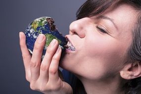 Woman is eating Earth shaped cookie