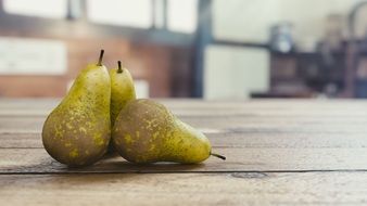 three pears on a wooden table close-up