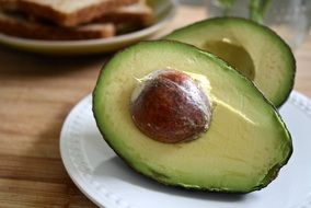 halves of avocado on a white plate