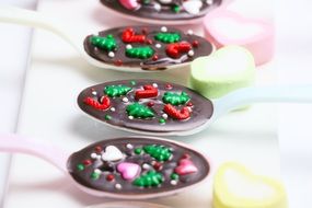 Chocolate with colorful toppings in spoons