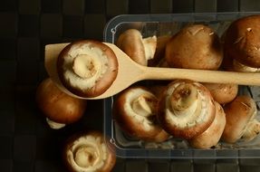 brown mushrooms in a wooden spoon