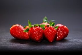 ripe red strawberries on the black background