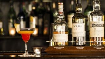 cocktail and three bottles of scotch whiskey