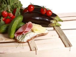 sandwich and vegetables on a wooden box