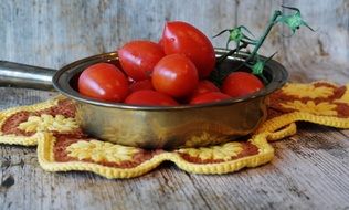 Red Tomatoes in pan on table