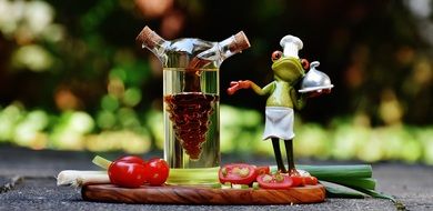 toy Frog in cook hat pointing to jar with Vinegar