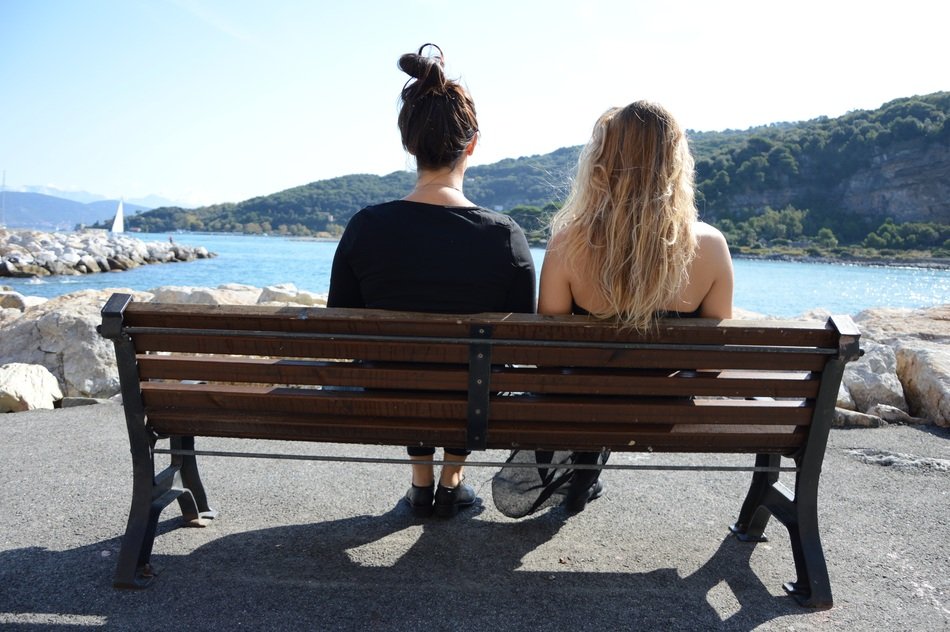 two girls resting on a bench in Italy