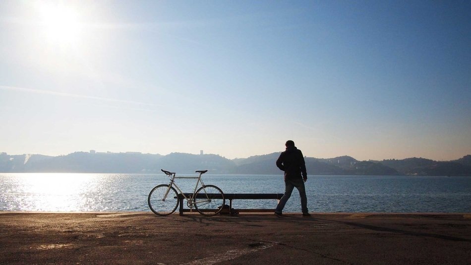 Single biker on a lake bank