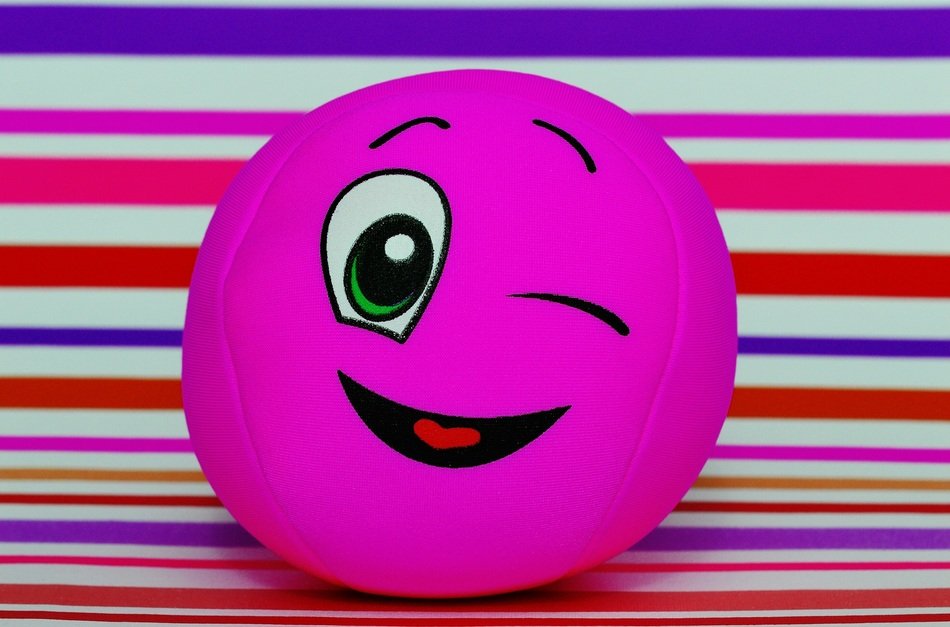 pink ball with a smile on a striped background