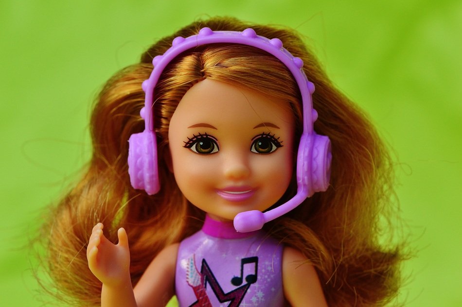 doll with lush hair in headphones with a microphone