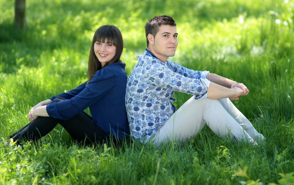 romantic couple sitting on the green grass