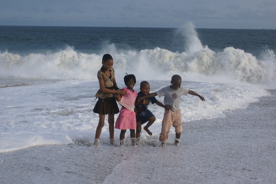 african kids in the spray of the ocean