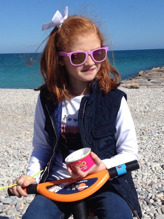 Child with sunglasses on a beach