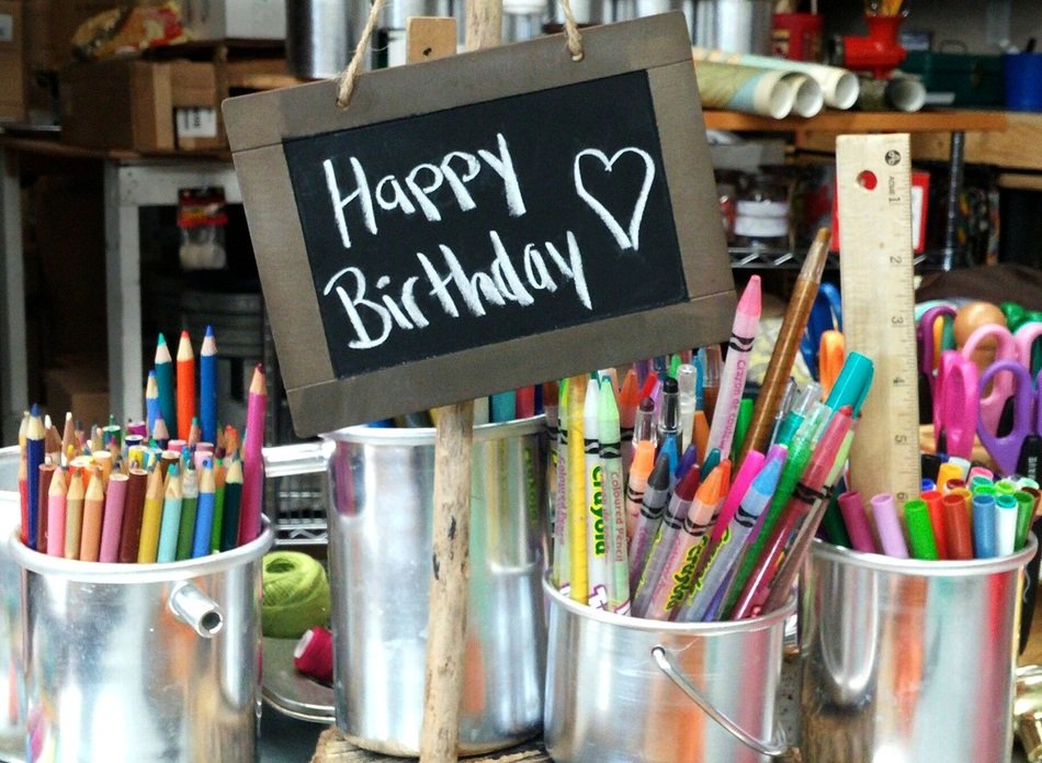 happy birthday text on the Board and glasses with pencils