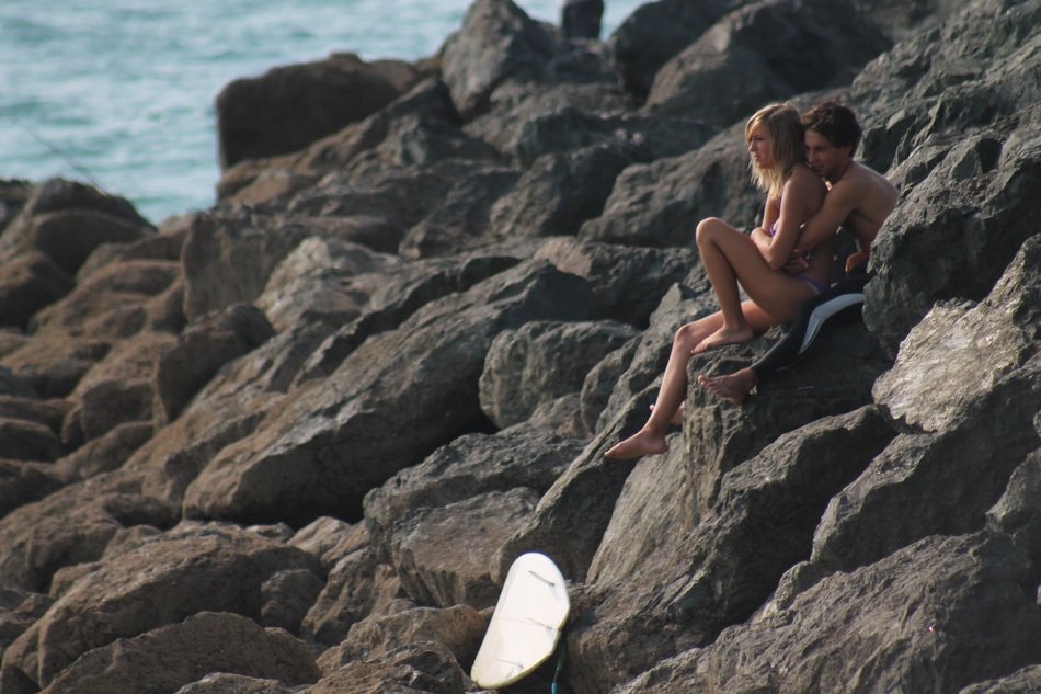couple in love on large stones on the coast