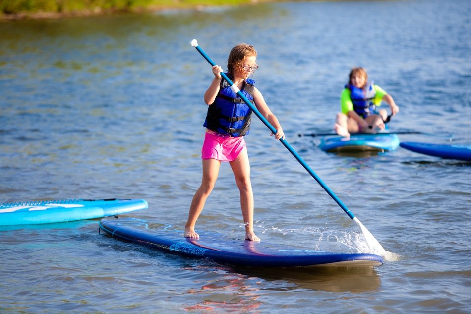 girls sports training in swimming on the boards with a paddle