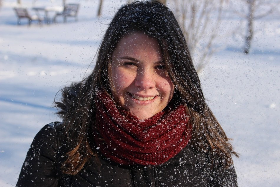 Smiling girl in the snow in winter