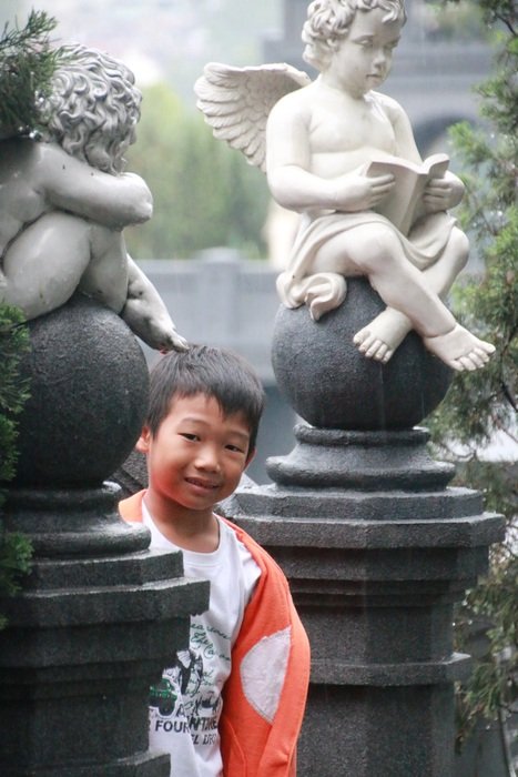 child among the sculptures in the park