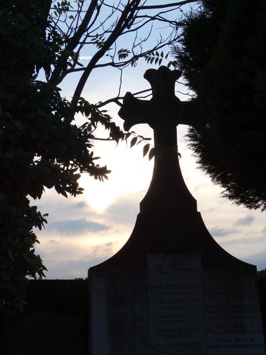 stone cross on the grave at dusk