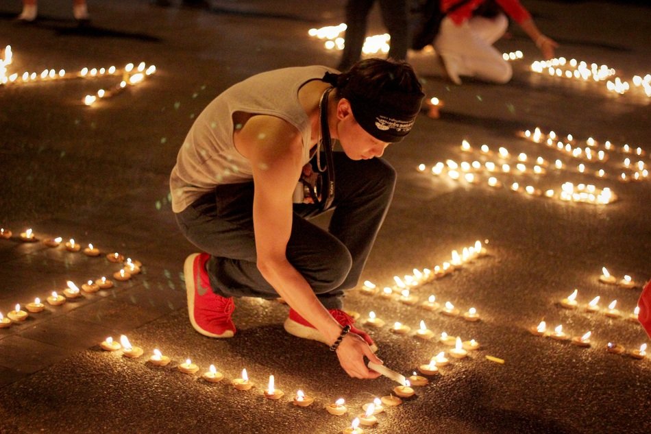 Student with Candle in the square at night