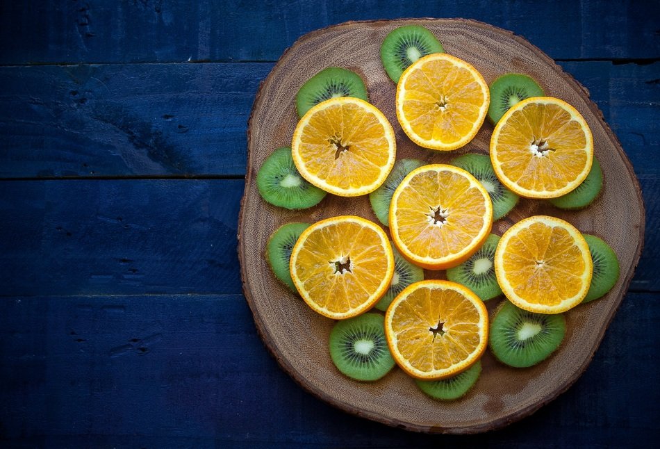 Orange and kiwi on a wooden