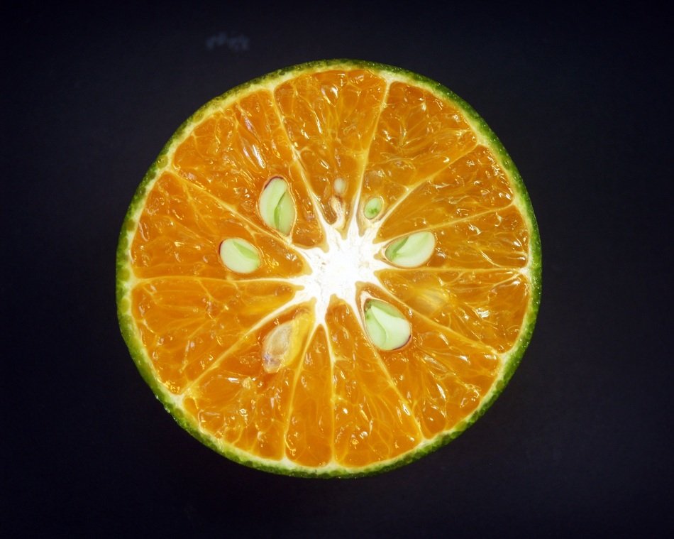 half of an orange on the black background