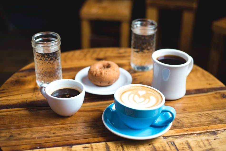 table setting for breakfast with water, coffee and doughnut