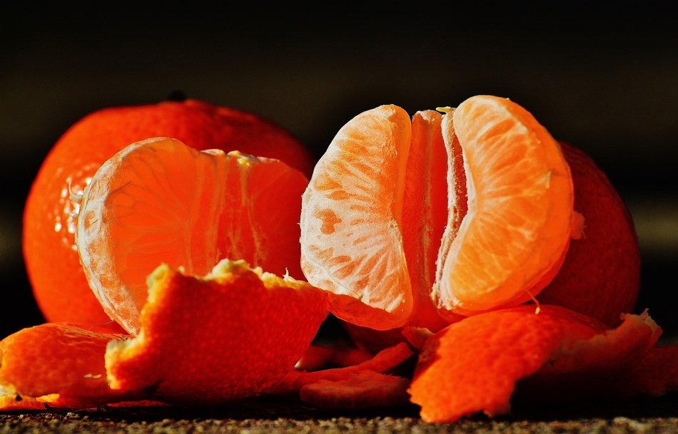peeled tangerines on black background
