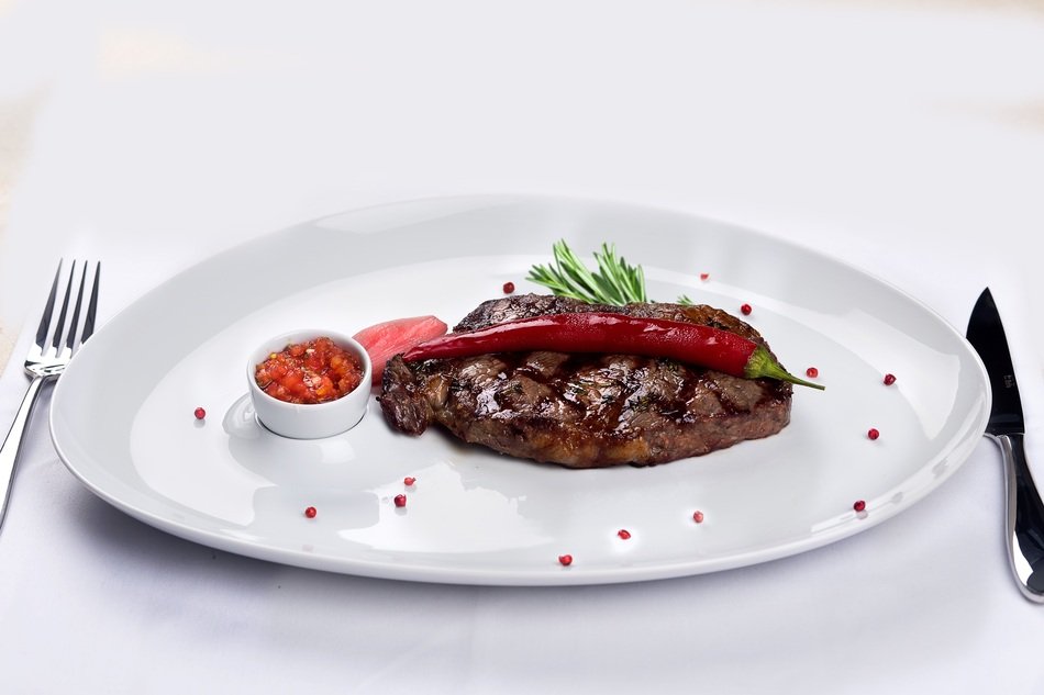 Steak in the restaurant on a white plate