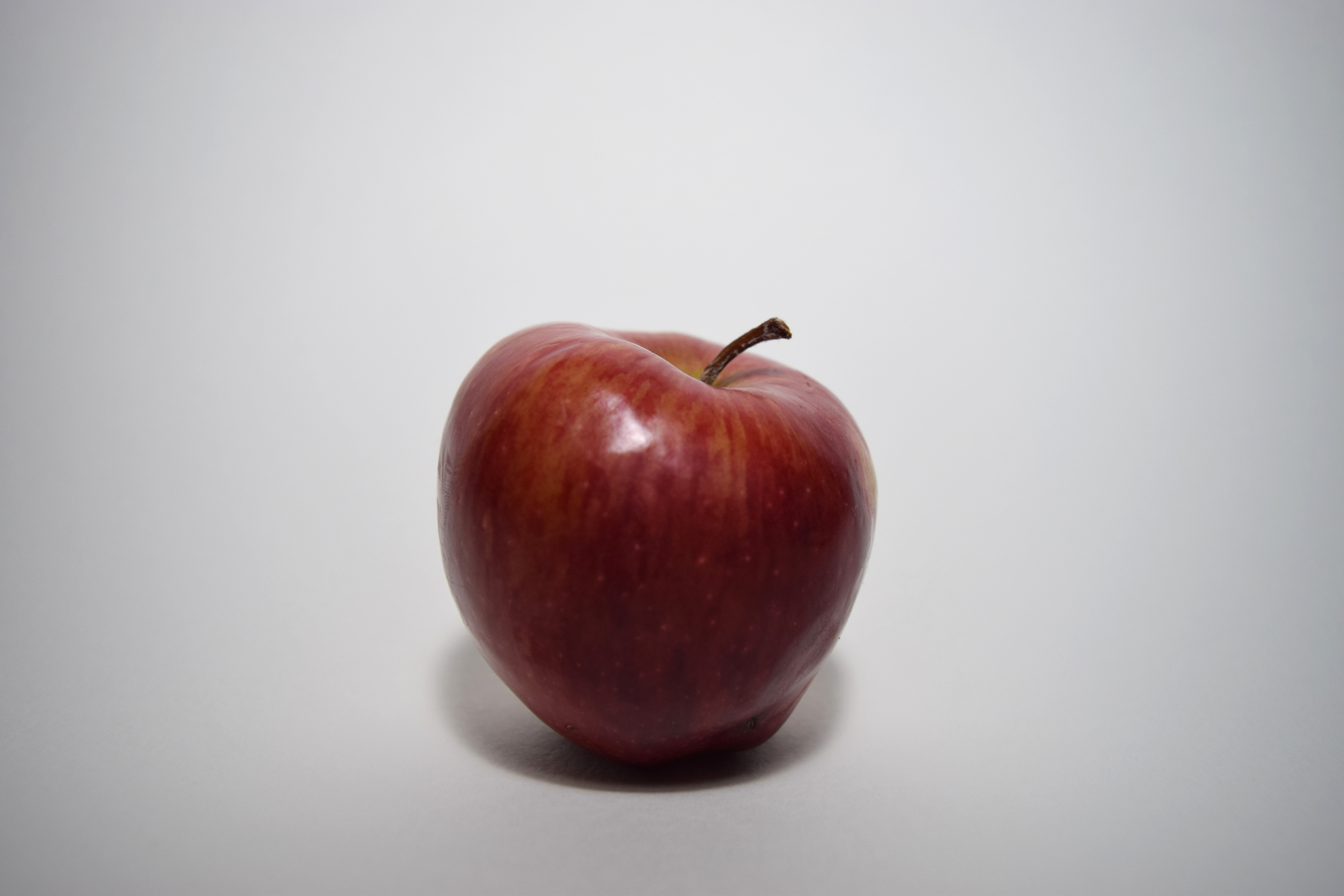 Apple is. Яблоко. Яблоко на сером фоне. Серая в яблоках. Одно яблоко на коричневом фоне