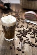 coffee grains near a coffee cup on a table