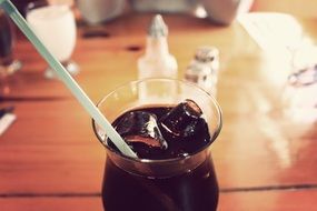 dark drink with ice and a straw close-up