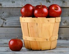 Wooden basket of the ripe fresh sweet red apples