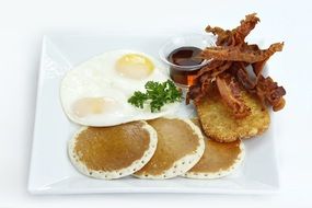 American breakfast with scrambled eggs, pancakes and bacon