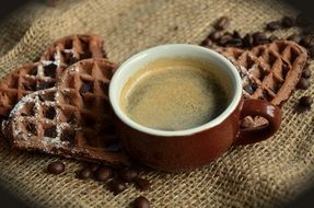 cup of coffee next to waffles