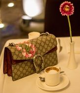 Gucci bag and cup of cappuccino