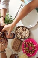 people at Lunch, hands above vegan food on table