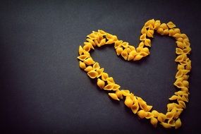 heart made of pasta on a dark surface