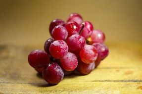 bunch of red grapes on a wooden table