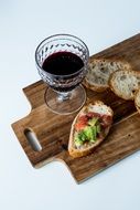 glass of wine and bread on a wooden board