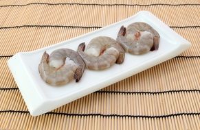 shrimps on a white plate on a bamboo stand