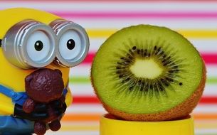 funny minion toy next to half of kiwi