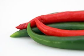 red green paprikas on white desk