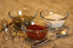 multi-colored seasonings in transparent bowls in the kitchen